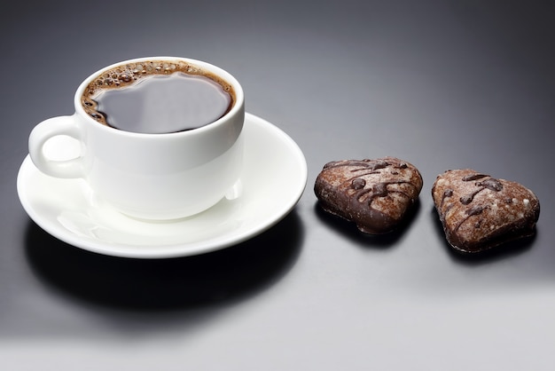 Bianco tazza di caffè nero con cuore di biscotti