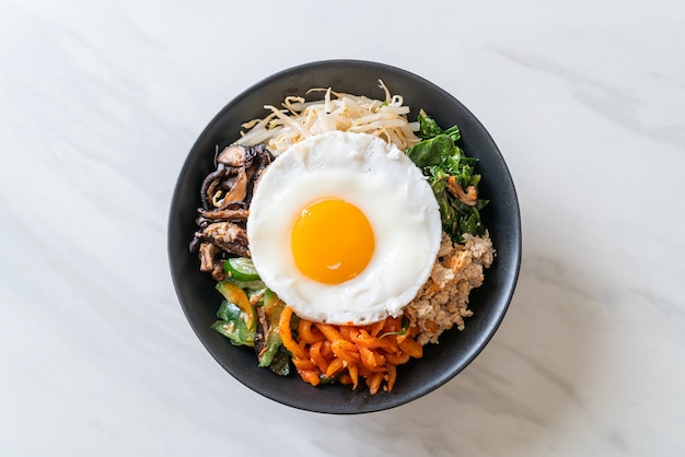 Bibimbap, insalata piccante coreana con riso e uovo fritto - stile di cucina tradizionalmente coreano