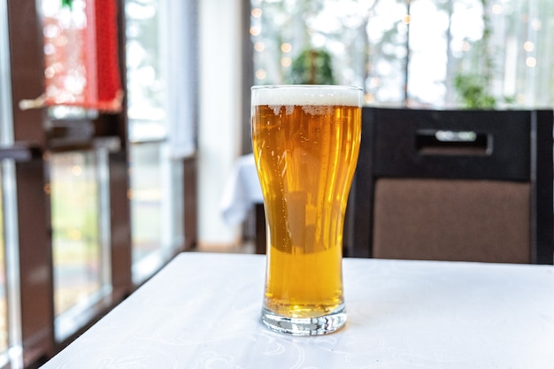 Bicchiere alto di birra sul tavolo di un pub