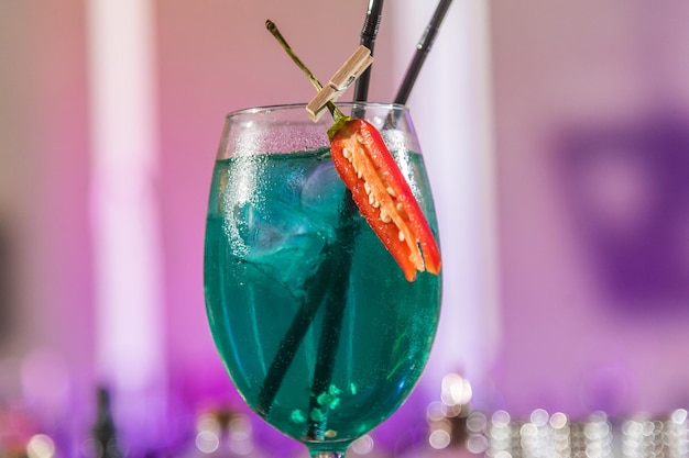 Bicchiere con cocktail di colore blu con peperoncino