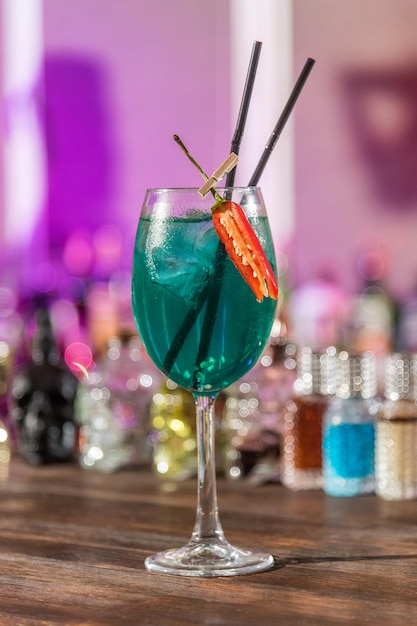 Bicchiere con cocktail di colore blu con peperoncino