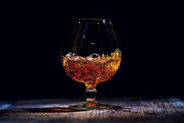 Bicchiere con cognac su fondo in legno