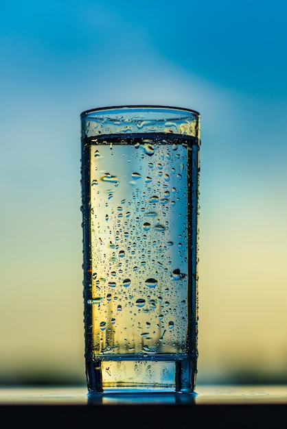 bicchiere con gocce d'acqua nel tramonto