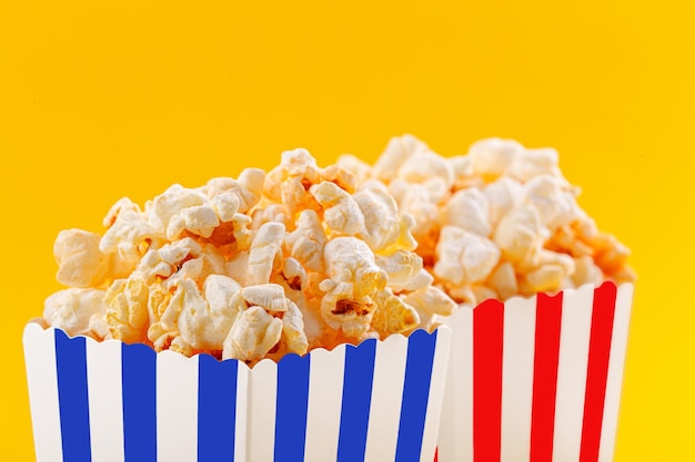 Bicchiere con popcorn su sfondo giallo