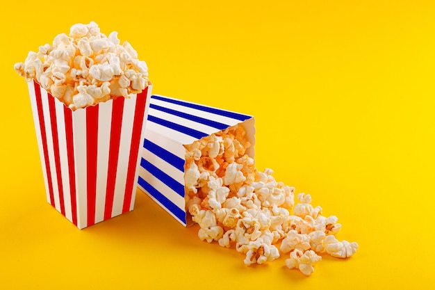 Bicchiere con popcorn su sfondo giallo