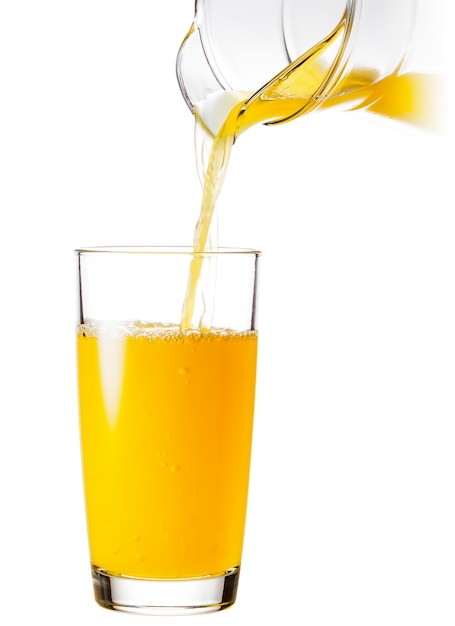 Bicchiere con una brocca di succo d'arancia versato da una brocca