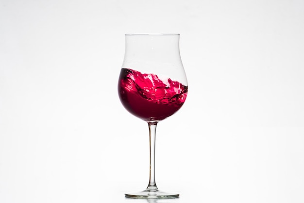 Bicchiere con vino rosso in movimento bicchiere tulipano enologia cantine bianco backgroundxA