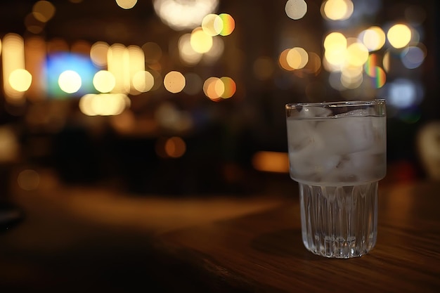 bicchiere d'acqua con ghiaccio al ristorante / acqua limpida e fredda in un bicchiere con pezzi di ghiaccio