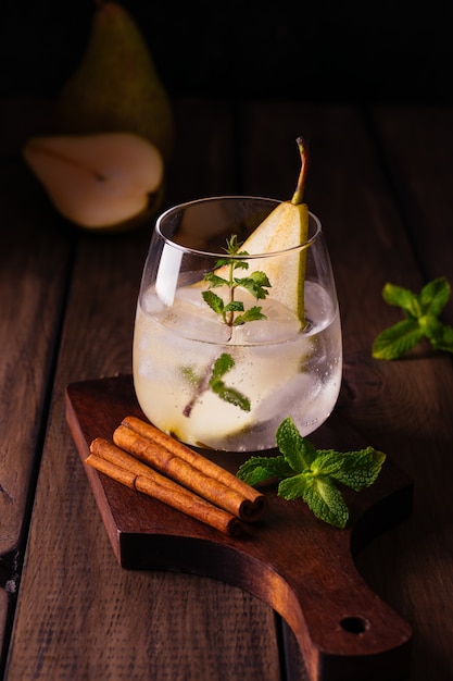 Bicchiere d'acqua con ghiaccio, pera e menta