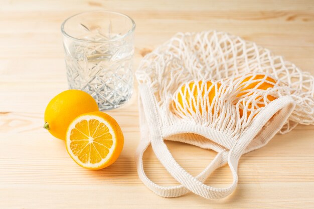 Bicchiere d'acqua con limone su un tavolo di legno, bevanda mattutina per uno stile di vita sano