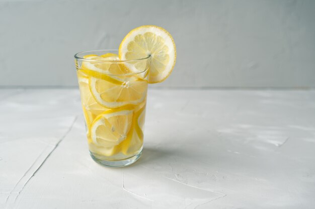 Bicchiere d'acqua con limone. Una dose d'urto di vitamina C per il trattamento dei virus. La lotta contro il coronovirus con una grande dose di vitamina C.