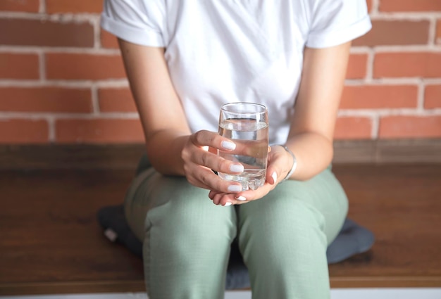 Bicchiere d'acqua della mano della donna