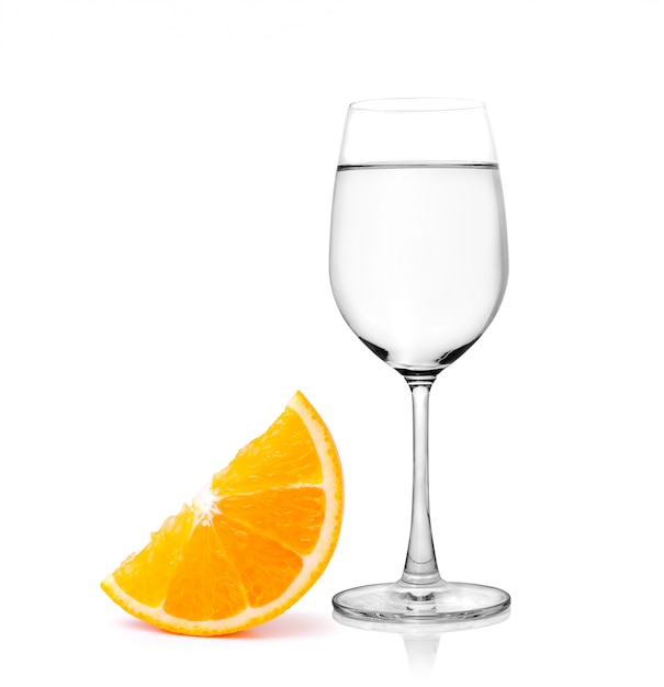 Bicchiere d'acqua e frutta a metà arancio su spazio bianco