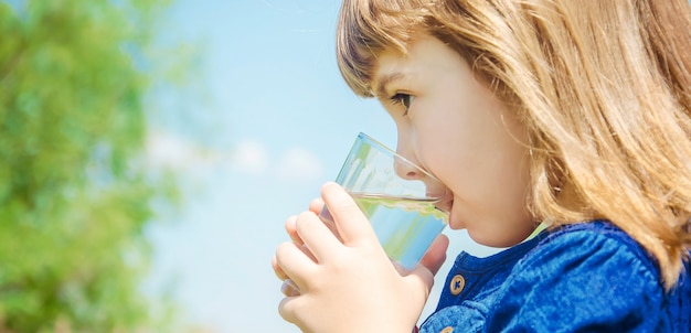 Bicchiere d&#39;acqua per bambini. messa a fuoco selettiva. natura.