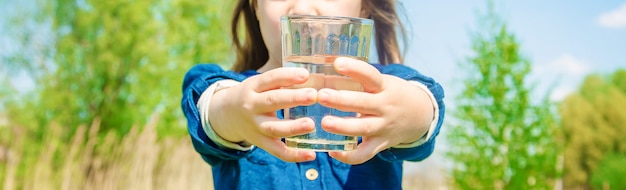 Bicchiere d&#39;acqua per bambini. messa a fuoco selettiva. natura.