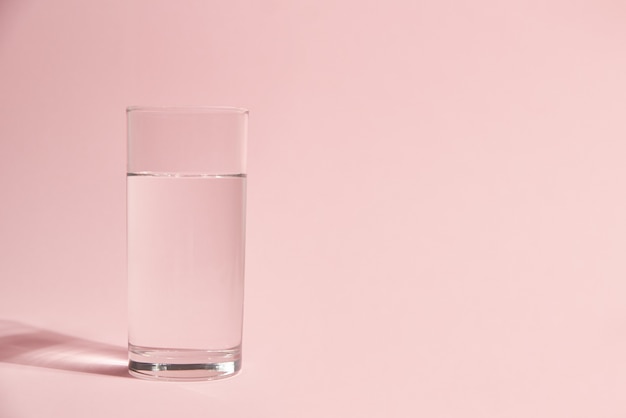 Bicchiere d'acqua sul rosa