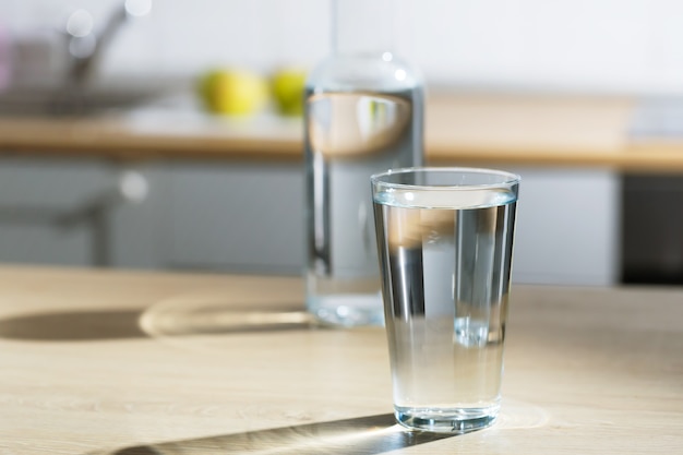 Bicchiere d'acqua viene versato in un bicchiere in un tavolo da cucina