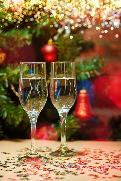 bicchiere da bere sul tavolo all'albero di Natale illuminato