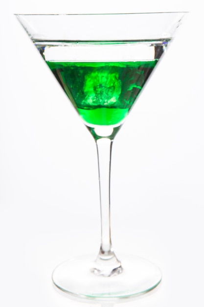 Bicchiere da cocktail con alcool verde vicino