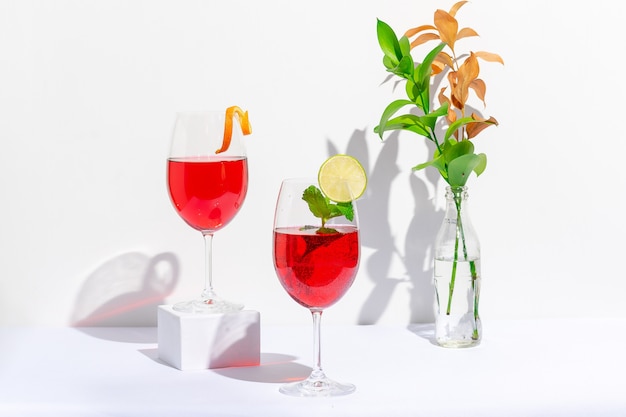 Bicchiere da cocktail rosso fatto di vodka e spumante su sfondo bianco