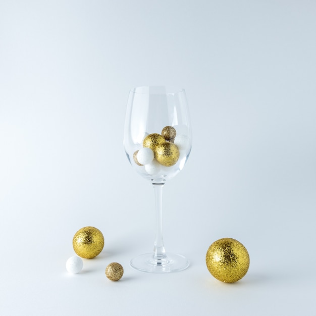 Bicchiere da vino con decoro glitter dorato e bianco su sfondo bianco