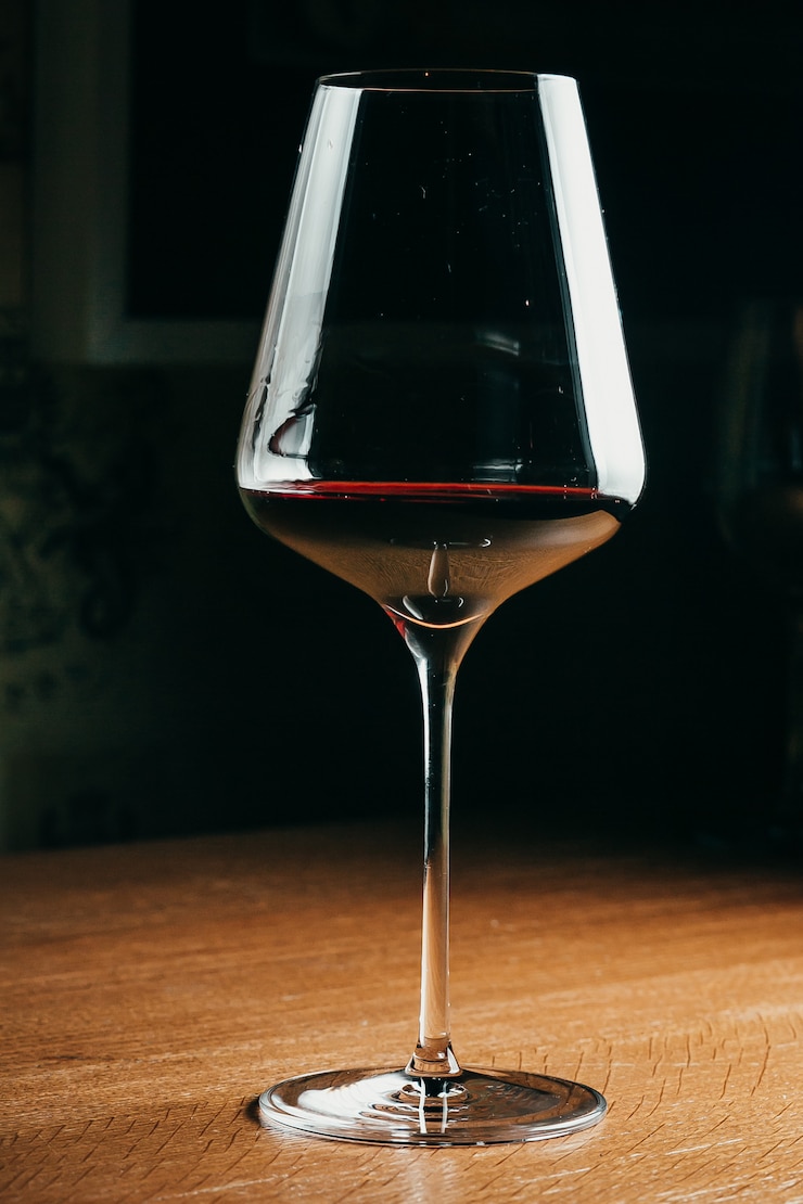 Foto bicchiere da vino nella sala divertente tra sfondo finestra al tramonto