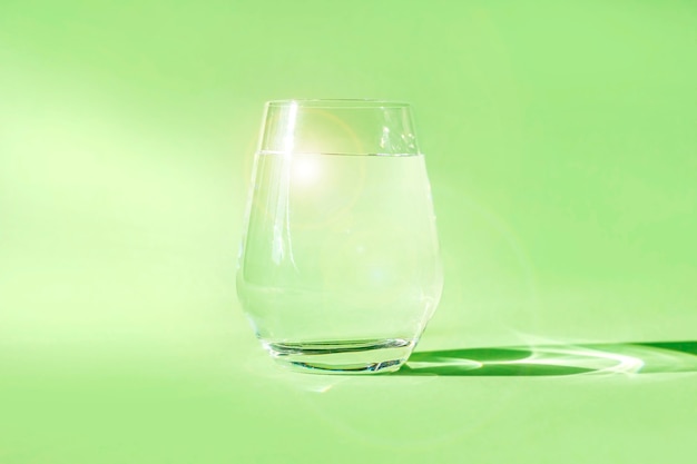 Bicchiere di acqua dolce pulita su sfondo verde. Acqua di sorgente ecologicamente pura. Detox, energia dell'acqua naturale.