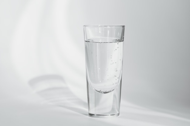 Bicchiere di acqua minerale pulita frizzante su uno sfondo bianco