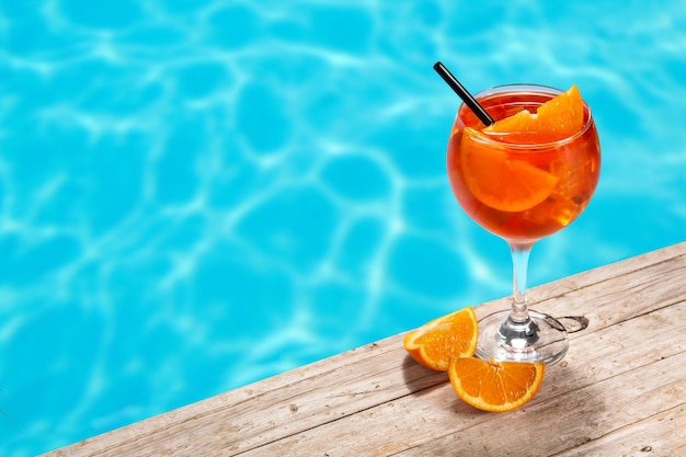 Bicchiere di aperol spritz cocktail e piscina