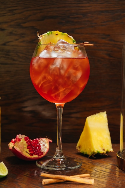 Bicchiere di Aperol Spritz ghiacciato servito in un bicchiere da vino con ananas e granato