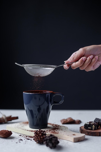 Bicchiere di bevanda al cacao al cioccolato caldo cosparsa di cacao in polvere.