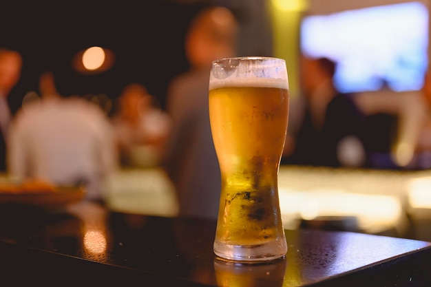 Bicchiere di birra collocato gettando un'ombra sul bancone dello sky bar nel ristorante. Birra fresca, perfetta per uscire dopo il lavoro. Birra, uscire, rilassarsi, ristorante, cena concept.