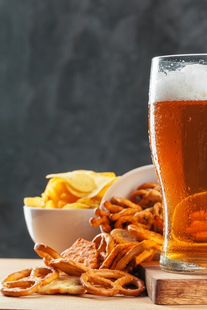 Bicchiere di birra con bretzel e snack di salsicce secche