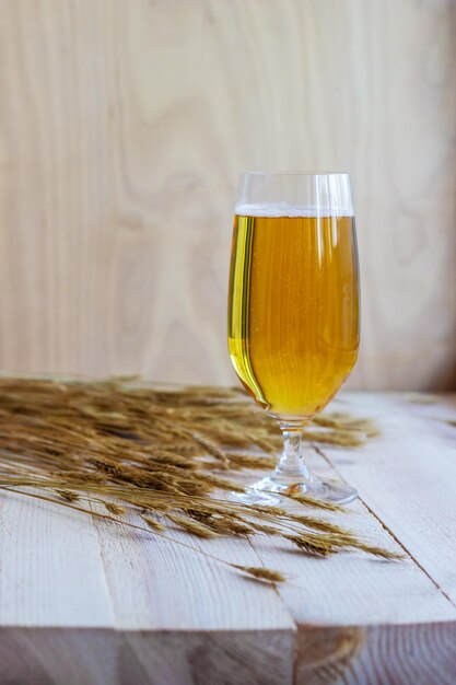 Bicchiere di birra con grano su fondo di legno