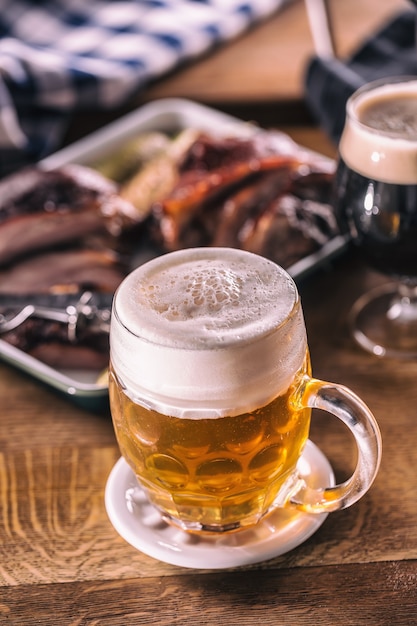 Bicchiere di birra leggera in pub o ristorante sul tavolo con cibo delizioso.