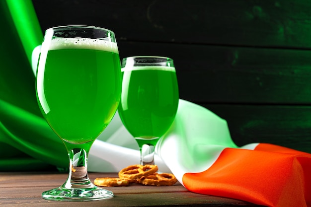 Bicchiere di birra verde contro la bandiera dell'Irlanda