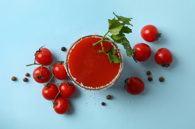 Bicchiere di Bloody Mary e pomodori su sfondo blu