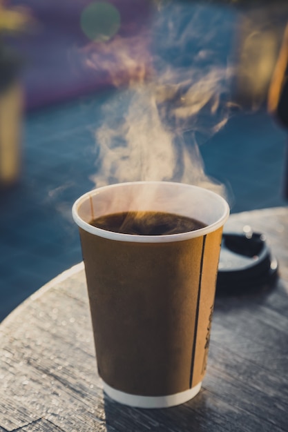 Bicchiere di carta con bevanda calda, caffè nero caldo con te