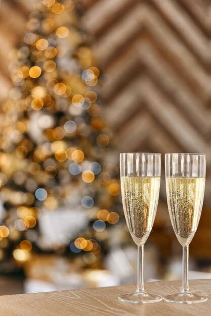 bicchiere di champagne sullo sfondo dell'albero di Capodanno con bokeh