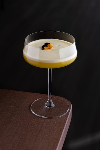 Bicchiere di cocktail al rum fruttato Papaya Caliente con frutta fresca di papaia