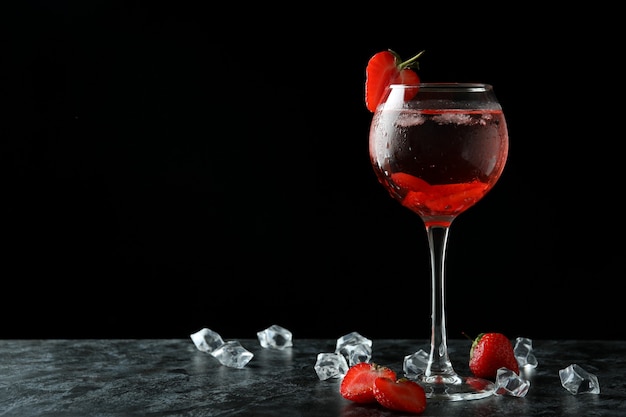 Bicchiere di cocktail alla fragola fresca sul tavolo affumicato nero