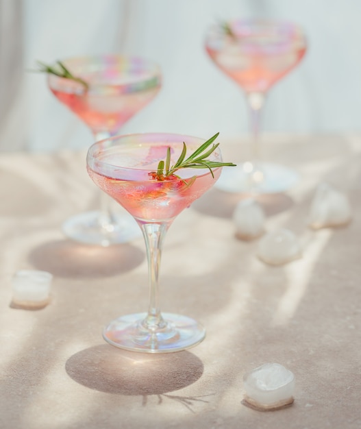 Bicchiere di cocktail alla fragola o mocktail, rinfrescante bevanda estiva con ghiaccio tritato e acqua frizzante sul beige