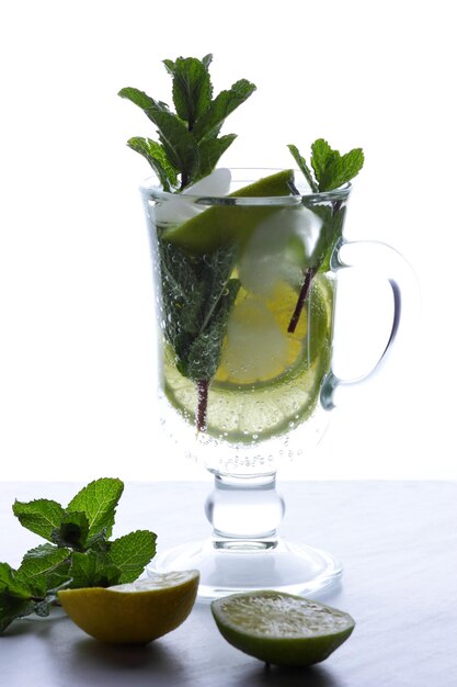 Bicchiere di cocktail con menta e agrumi su sfondo chiaro Bevanda fresca e sana al limone fredda Acqua con limone Closeup