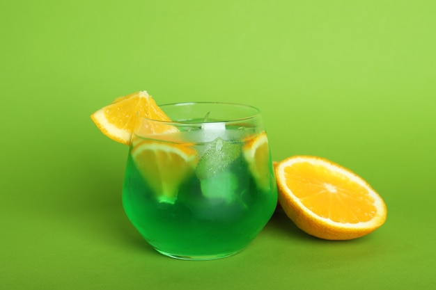 Bicchiere di cocktail di agrumi e ingredienti su sfondo verde