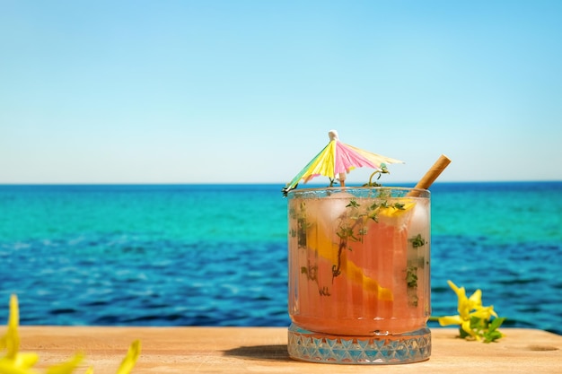 Bicchiere di cocktail di pompelmo e timo al bar sulla spiaggia