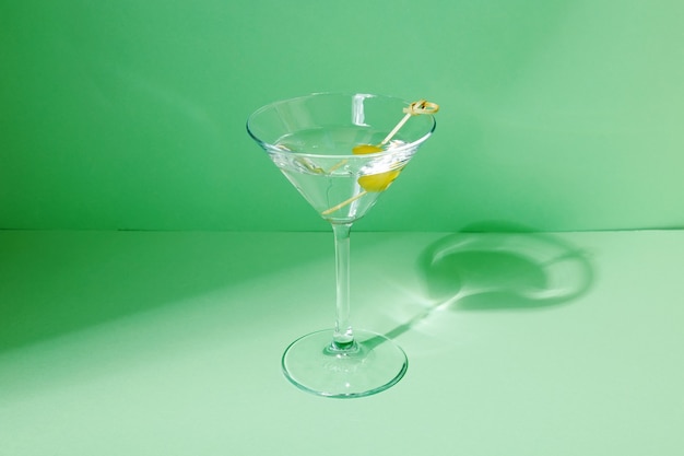 Bicchiere di cocktail martini con olive verdi. Concentrati sulle ombre