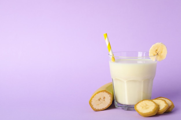 Bicchiere di frappè alla banana su sfondo viola