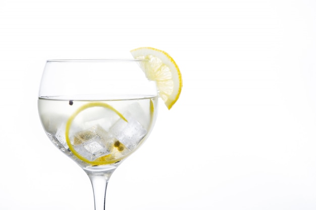 Bicchiere di gin tonic con limone isolato su sfondo bianco