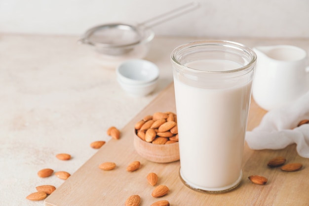 Bicchiere di gustoso latte di mandorle su sfondo chiaro