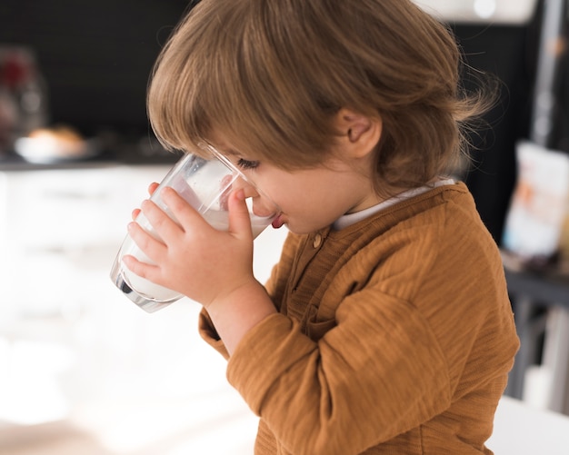 Bicchiere di latte bevente del bambino di vista frontale